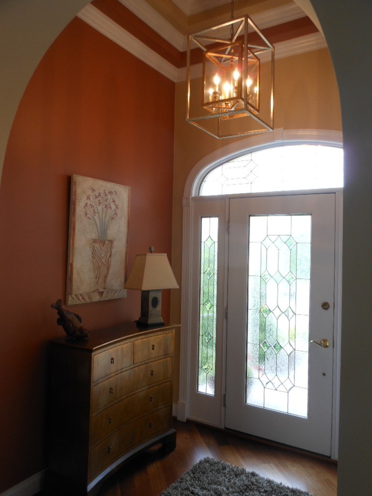 Foyer - mid-sized transitional medium tone wood floor foyer idea in DC Metro with yellow walls and a white front door