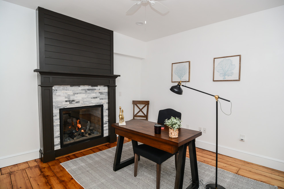 Design ideas for a contemporary study room in Boston with white walls, light hardwood floors, a two-sided fireplace, a tile fireplace surround, a freestanding desk and brown floor.