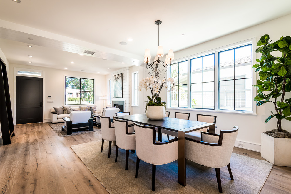 This is an example of a transitional dining room in Los Angeles with white walls and light hardwood floors.