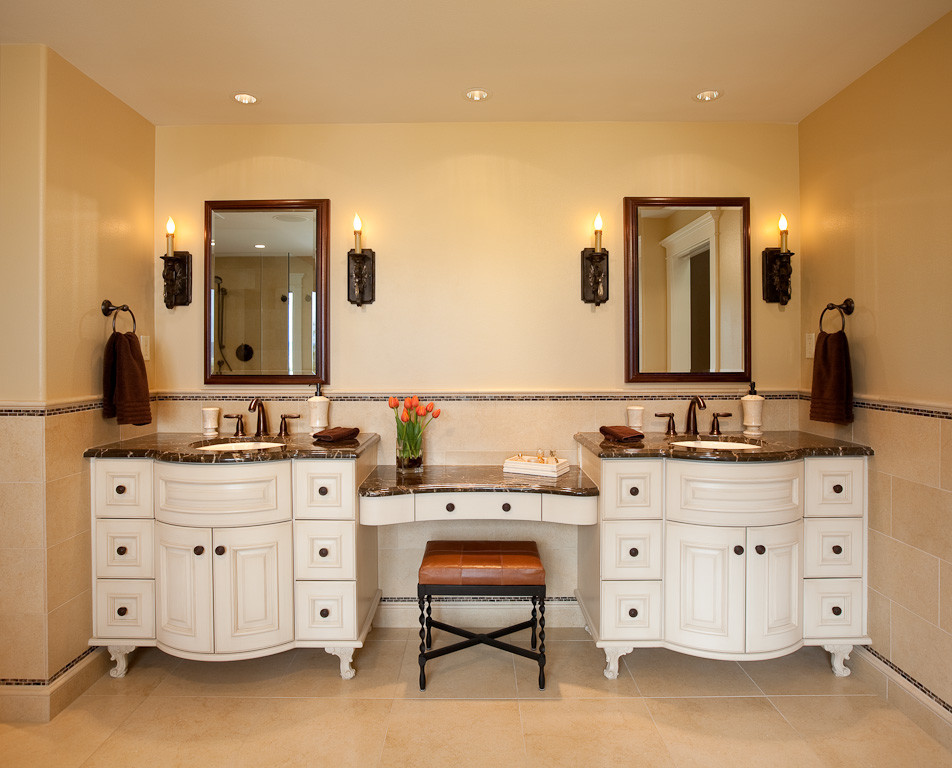 This is an example of a large traditional master bathroom in Seattle with an undermount sink, furniture-like cabinets, white cabinets, marble benchtops, a drop-in tub, a double shower, a bidet, beige tile, stone tile, yellow walls and limestone floors.