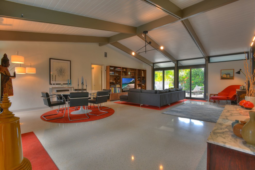 This is an example of a large midcentury open concept living room in Miami with grey walls, concrete floors, no fireplace, a built-in media wall and grey floor.