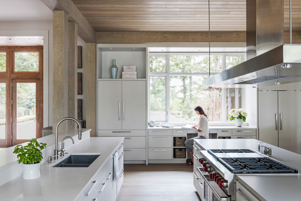 Design ideas for a large country galley open plan kitchen in Charlotte with an undermount sink, flat-panel cabinets, white cabinets, quartz benchtops, white splashback, stainless steel appliances, medium hardwood floors, multiple islands and grey floor.