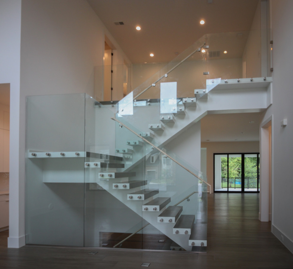 This is an example of an expansive modern wood floating staircase in DC Metro with glass railing.