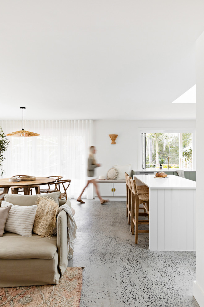 Design ideas for a mid-sized beach style l-shaped open plan kitchen in Central Coast with an undermount sink, flat-panel cabinets, green cabinets, quartz benchtops, white splashback, terra-cotta splashback, white appliances, concrete floors, with island, grey floor and white benchtop.