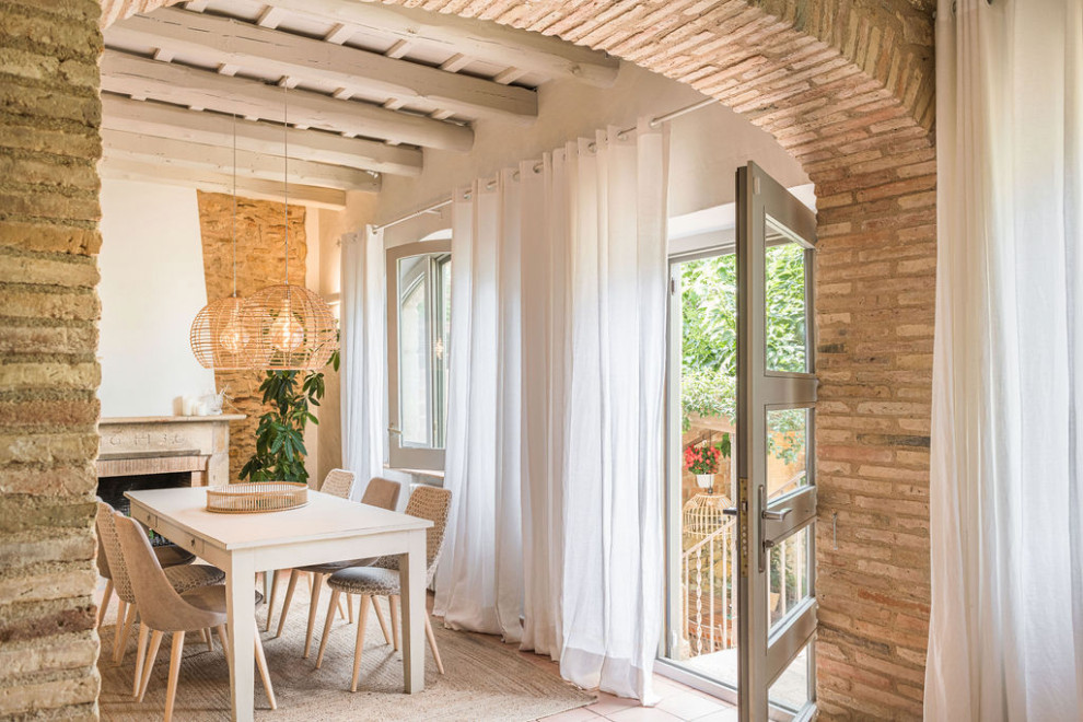 Diseño de comedor campestre de tamaño medio con suelo de baldosas de terracota, todas las chimeneas, marco de chimenea de piedra, vigas vistas y todos los tratamientos de pared