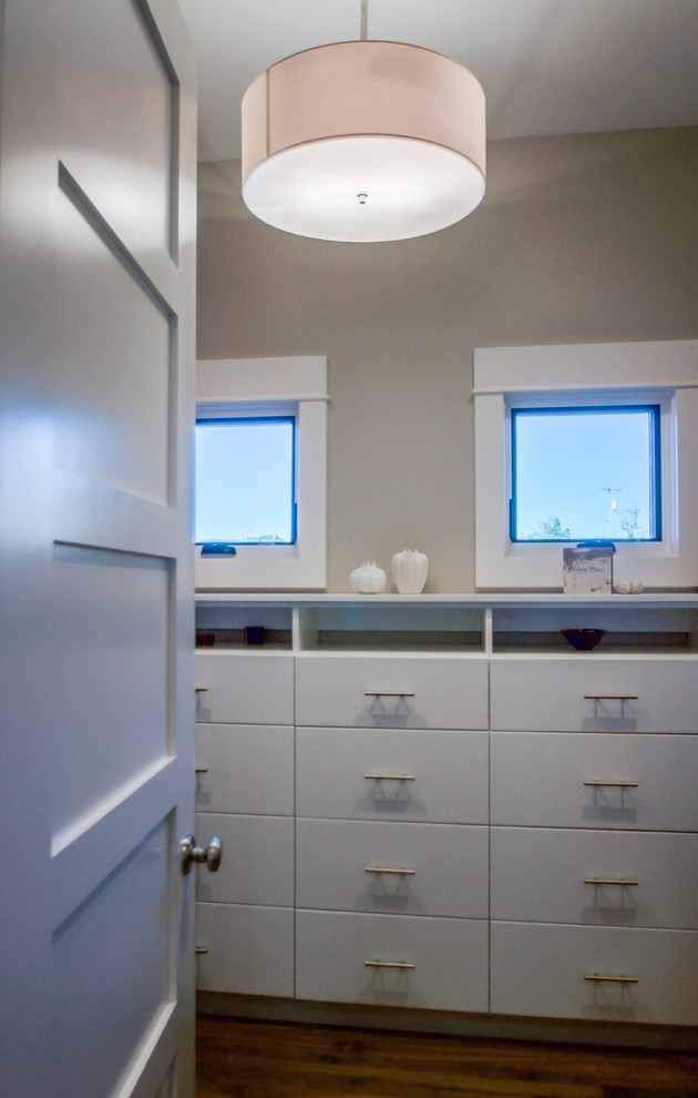Contemporary gender-neutral walk-in wardrobe in Salt Lake City with flat-panel cabinets, white cabinets and medium hardwood floors.