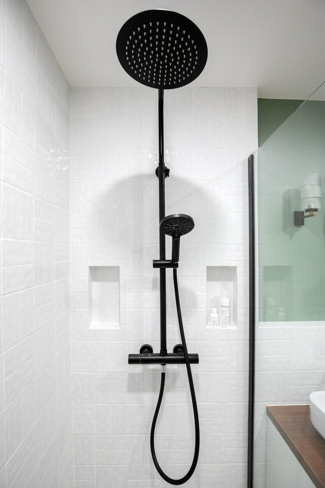 Ejemplo de cuarto de baño principal contemporáneo de tamaño medio con ducha a ras de suelo, baldosas y/o azulejos blancos, baldosas y/o azulejos de cerámica, paredes blancas y hornacina