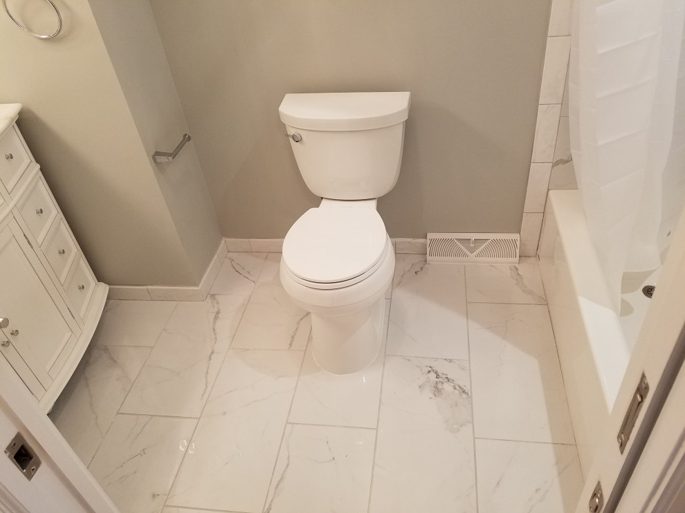 Exemple d'une salle de bain principale chic de taille moyenne avec des portes de placard blanches, une baignoire en alcôve, un combiné douche/baignoire, un carrelage multicolore, un mur gris, un lavabo encastré, un plan de toilette en marbre, un sol blanc, une cabine de douche avec un rideau, un plan de toilette blanc, une niche, meuble simple vasque et meuble-lavabo encastré.