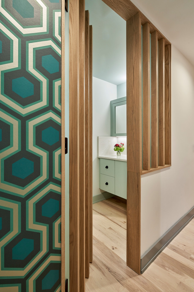 Photo of a mid-sized midcentury kids bathroom in Charlotte with flat-panel cabinets, turquoise cabinets, an alcove tub, a shower/bathtub combo, a two-piece toilet, white tile, porcelain tile, white walls, light hardwood floors, an undermount sink, engineered quartz benchtops, brown floor, a shower curtain, white benchtops, a niche, a single vanity, a floating vanity and wood walls.