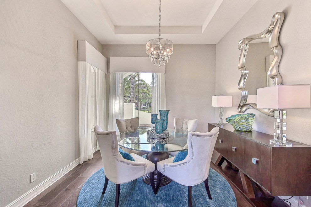 Photo of a beach style separate dining room in Miami with grey walls, dark hardwood floors and blue floor.