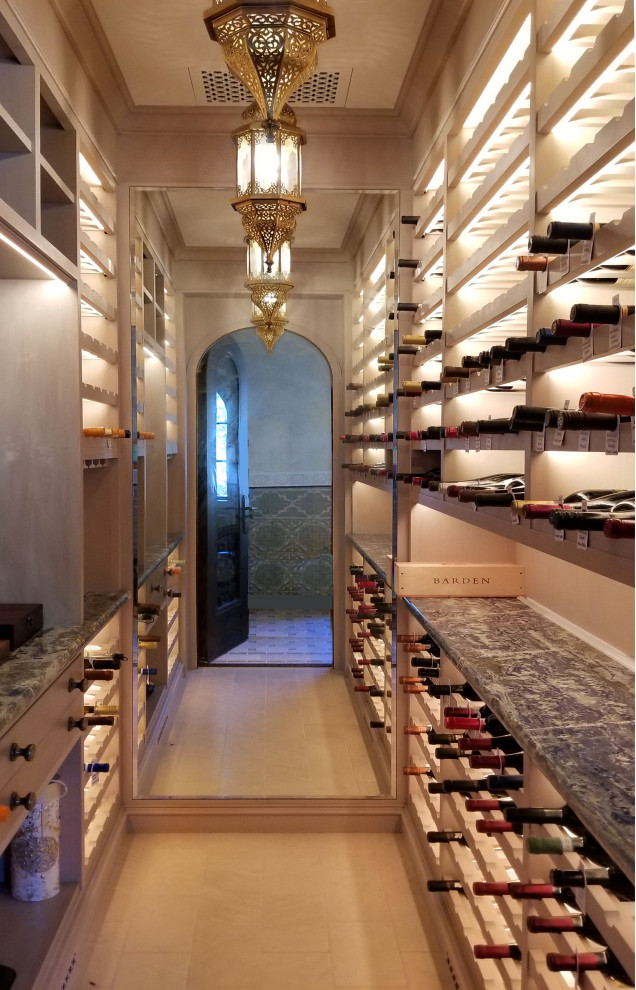 This is an example of a mid-sized mediterranean wine cellar in Santa Barbara with travertine floors, storage racks and yellow floor.