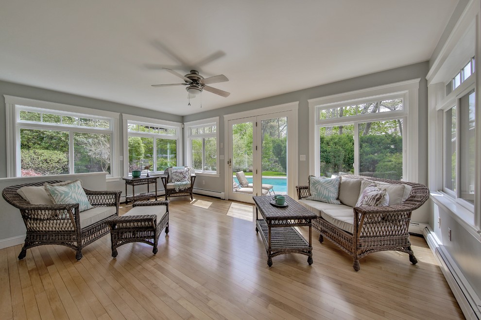 Large beach style sunroom in Boston with light hardwood floors, a standard ceiling, no fireplace and brown floor.