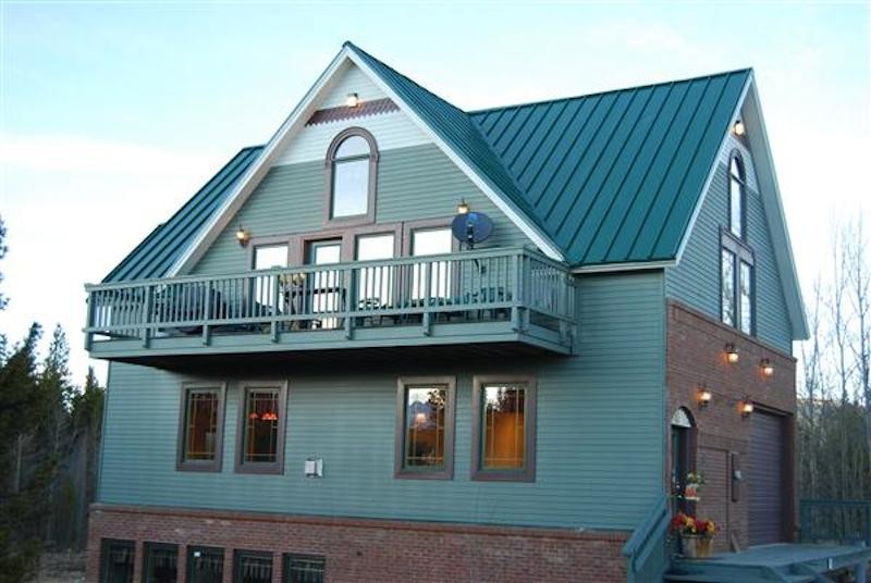 Design ideas for a large traditional two-storey blue house exterior in Denver with wood siding, a gable roof and a metal roof.