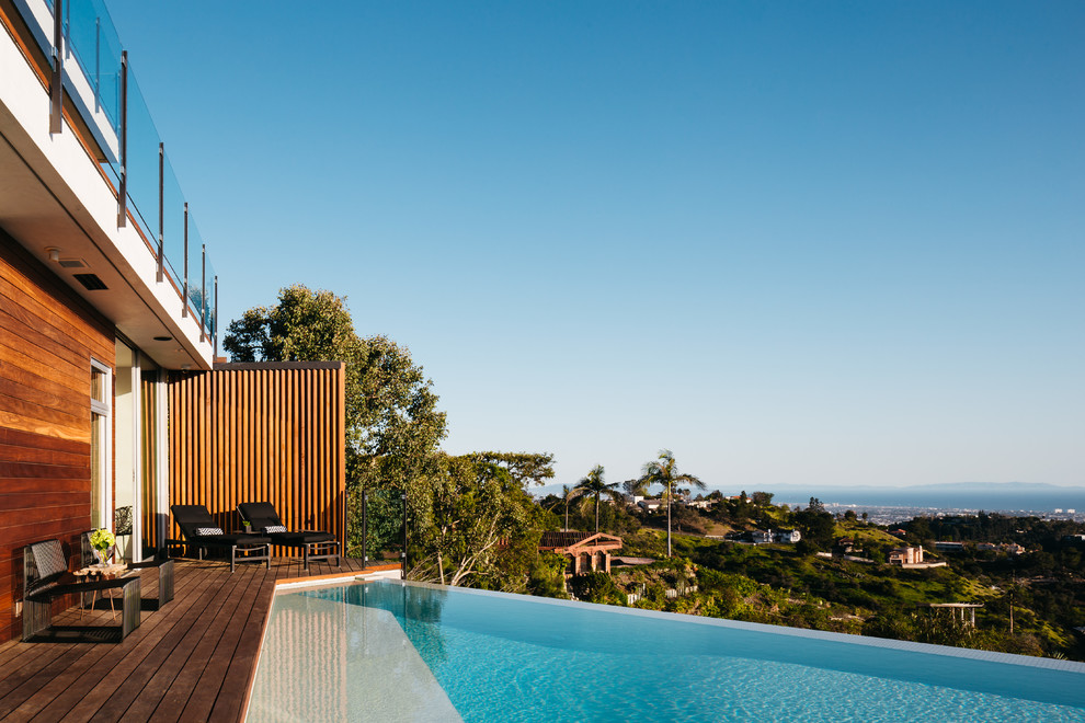 Inspiration for a contemporary custom-shaped infinity pool in Orange County with decking.