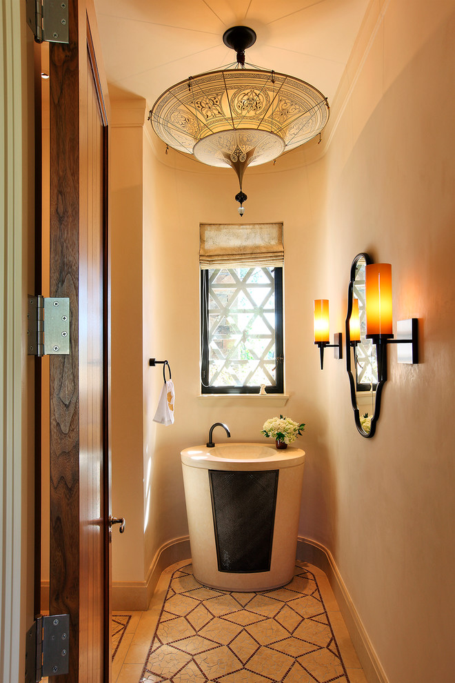 This is an example of an expansive mediterranean powder room in San Francisco with a pedestal sink and beige walls.