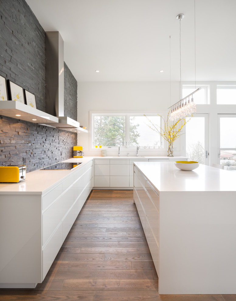 Modern kitchen in Portland with flat-panel cabinets, white cabinets, grey splashback, slate splashback and white benchtop.