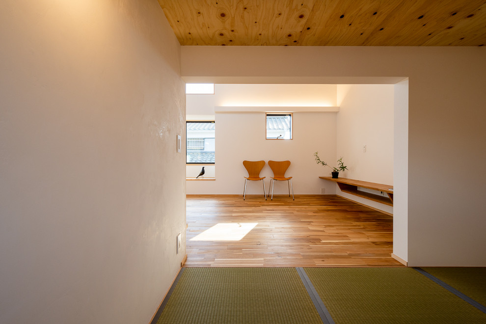 Стильный дизайн: маленькая открытая гостиная комната в скандинавском стиле с белыми стенами, татами, зеленым полом, балками на потолке и обоями на стенах без камина, телевизора для на участке и в саду - последний тренд