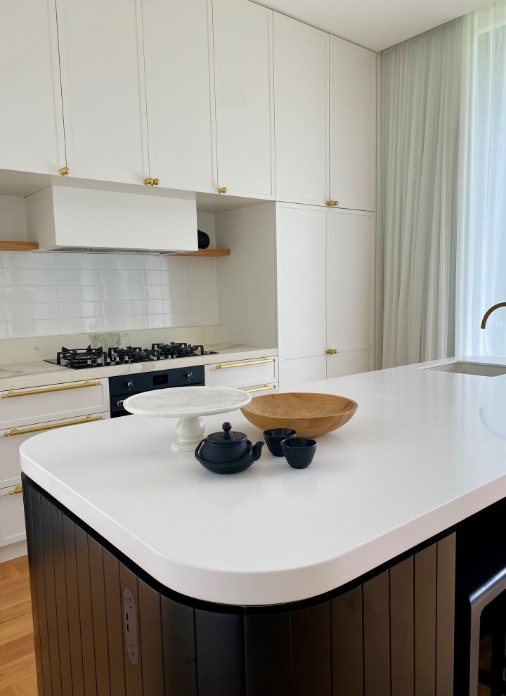 Inspiration for a mid-sized contemporary galley eat-in kitchen in Sydney with shaker cabinets, black cabinets, solid surface benchtops and with island.
