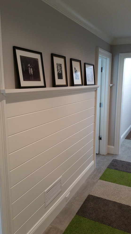 Photo of a mid-sized transitional hallway in New York with grey walls and light hardwood floors.
