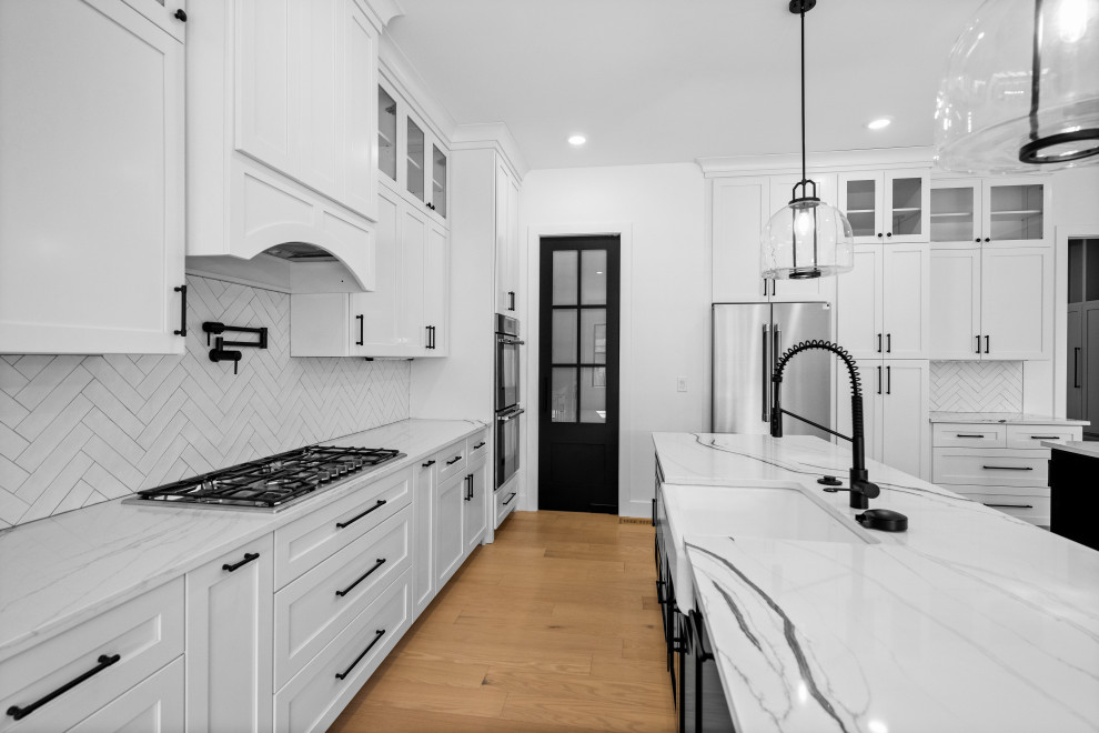 Eat-in kitchen - large transitional eat-in kitchen idea in Cincinnati with a single-bowl sink, shaker cabinets, white cabinets, quartzite countertops, white backsplash, ceramic backsplash, stainless steel appliances, two islands and white countertops