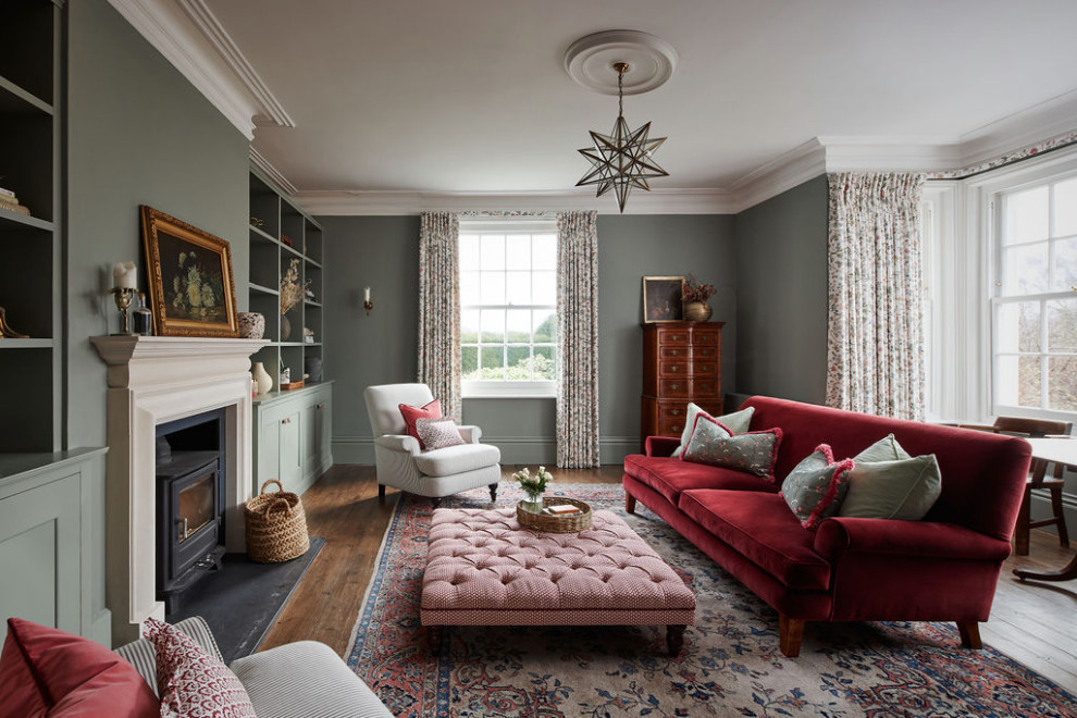 This is an example of a medium sized rural grey and pink living room curtain in Kent with grey walls, medium hardwood flooring, a wood burning stove and brown floors.