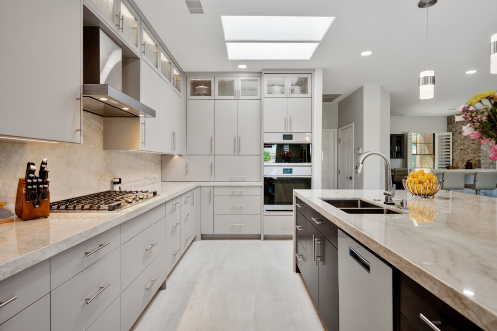 Large contemporary l-shaped eat-in kitchen in Phoenix with an undermount sink, flat-panel cabinets, grey cabinets, quartzite benchtops, beige splashback, stainless steel appliances, porcelain floors, with island, beige floor and beige benchtop.