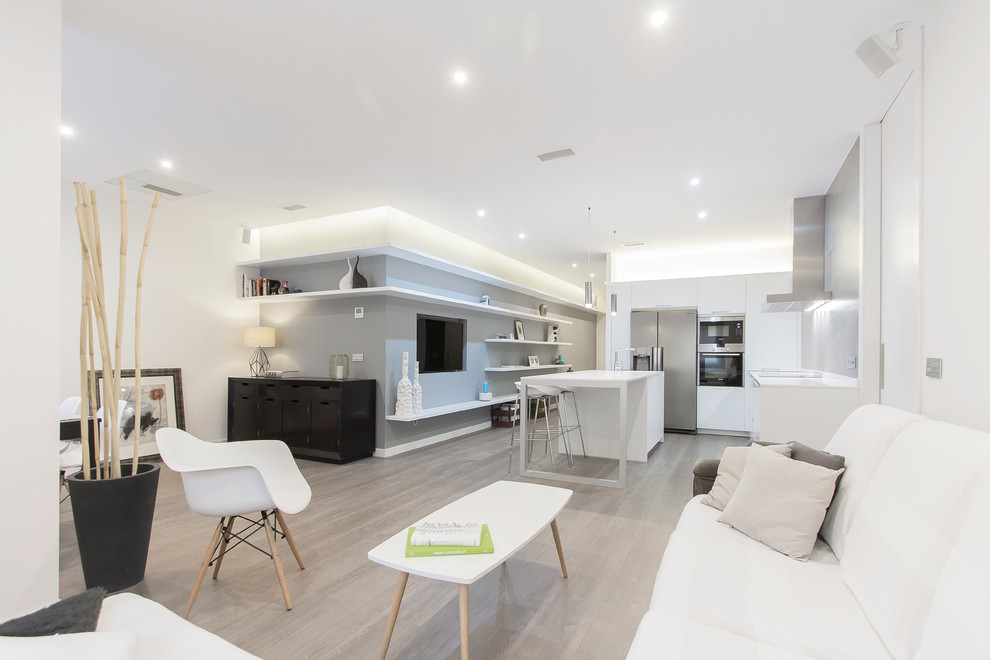 Mid-sized modern l-shaped open plan kitchen in Madrid with an integrated sink, flat-panel cabinets, white cabinets, quartz benchtops, grey splashback, cement tile splashback, stainless steel appliances, medium hardwood floors and with island.