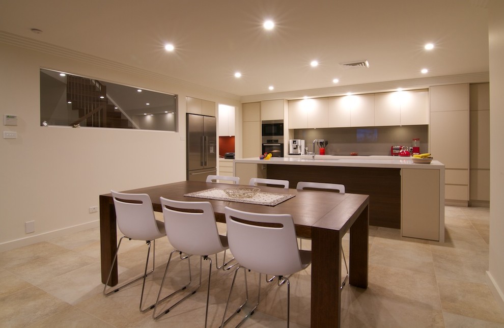 Inspiration for a mid-sized contemporary galley open plan kitchen in Sydney with an undermount sink, flat-panel cabinets, beige cabinets, quartz benchtops, brown splashback, glass sheet splashback, stainless steel appliances, travertine floors, with island, beige floor and beige benchtop.