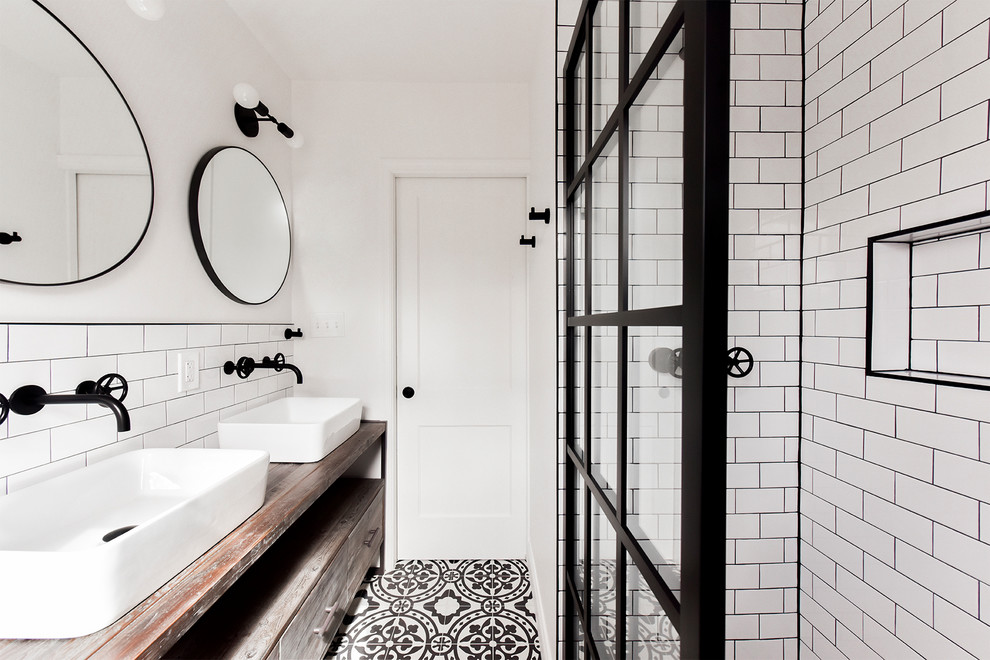 Industrial bathroom in DC Metro with medium wood cabinets, a corner shower, white tile, subway tile, white walls, cement tiles, a vessel sink, wood benchtops, multi-coloured floor, an open shower, brown benchtops and flat-panel cabinets.