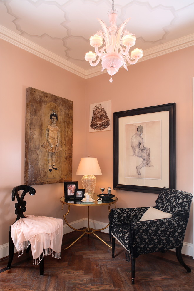 This is an example of an eclectic living room in Atlanta with pink walls and brown floor.