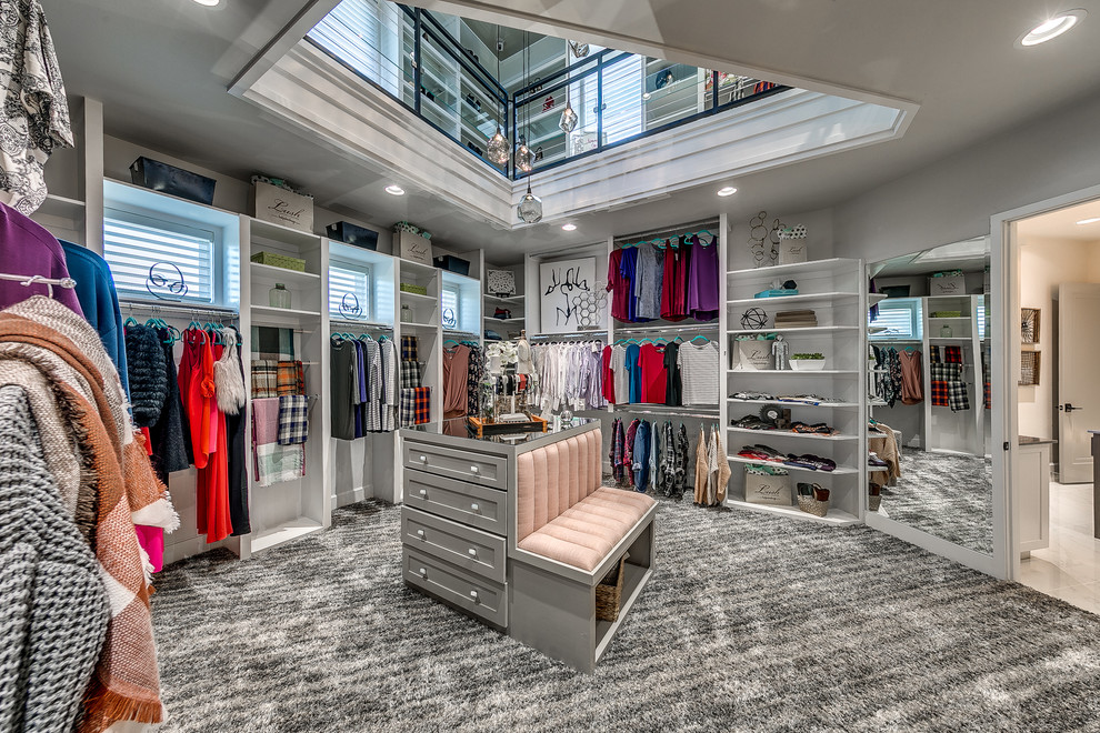 Photo of a large transitional women's dressing room in Oklahoma City with open cabinets, white cabinets, carpet and grey floor.