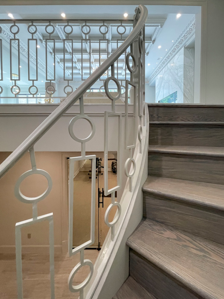 Ejemplo de escalera suspendida clásica renovada extra grande con escalones de madera, contrahuellas de madera, barandilla de metal y panelado