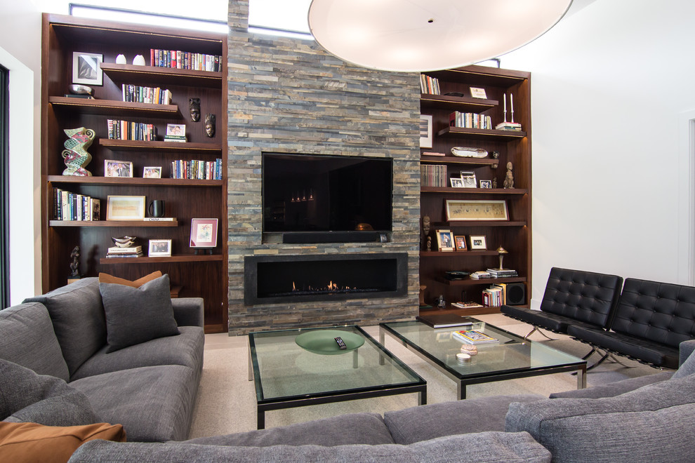 Inspiration for a large midcentury open concept living room in Dallas with a library, white walls, porcelain floors, a ribbon fireplace, a stone fireplace surround, a built-in media wall and beige floor.