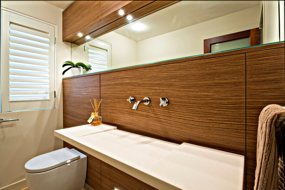 This is an example of a contemporary bathroom in Perth with flat-panel cabinets, medium wood cabinets, a one-piece toilet, black and white tile, white walls, ceramic floors and an integrated sink.