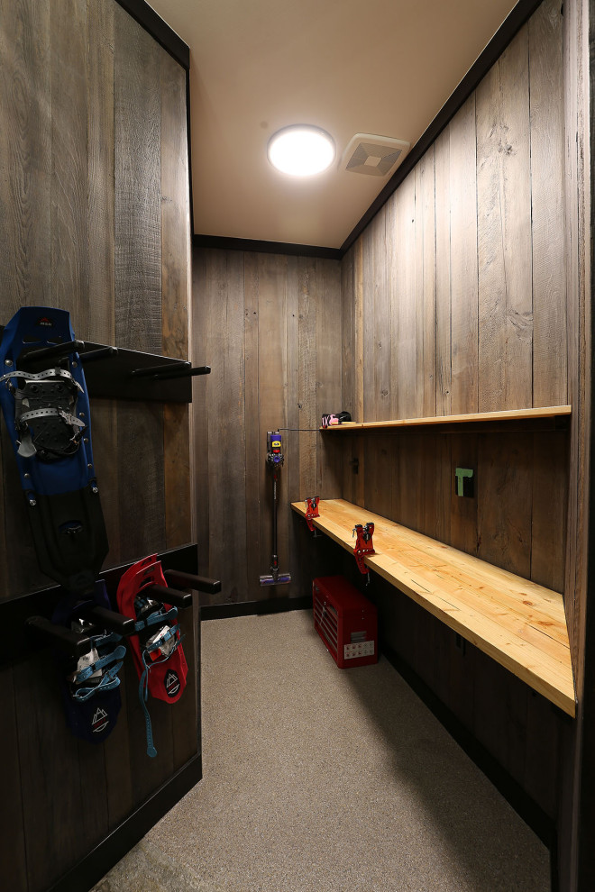 Example of a large mountain style gray floor mudroom design with a dark wood front door