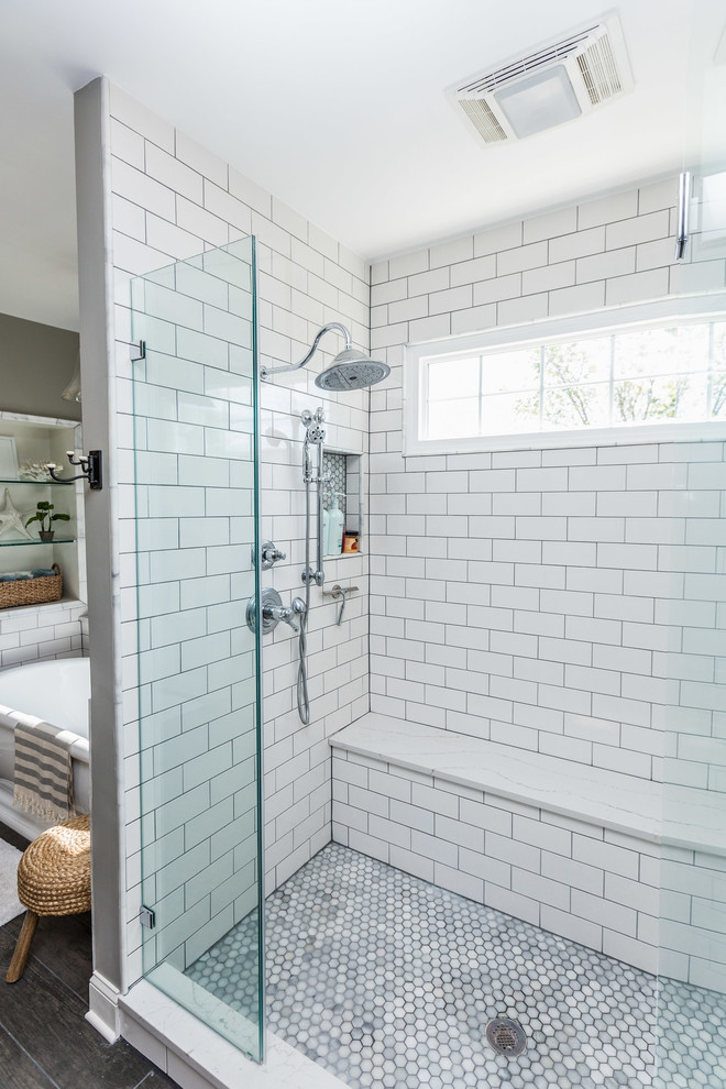Inspiration for a large traditional master bathroom in DC Metro with shaker cabinets, white cabinets, a freestanding tub, an alcove shower, white tile, subway tile, grey walls, dark hardwood floors, an undermount sink, engineered quartz benchtops, brown floor, a hinged shower door and grey benchtops.