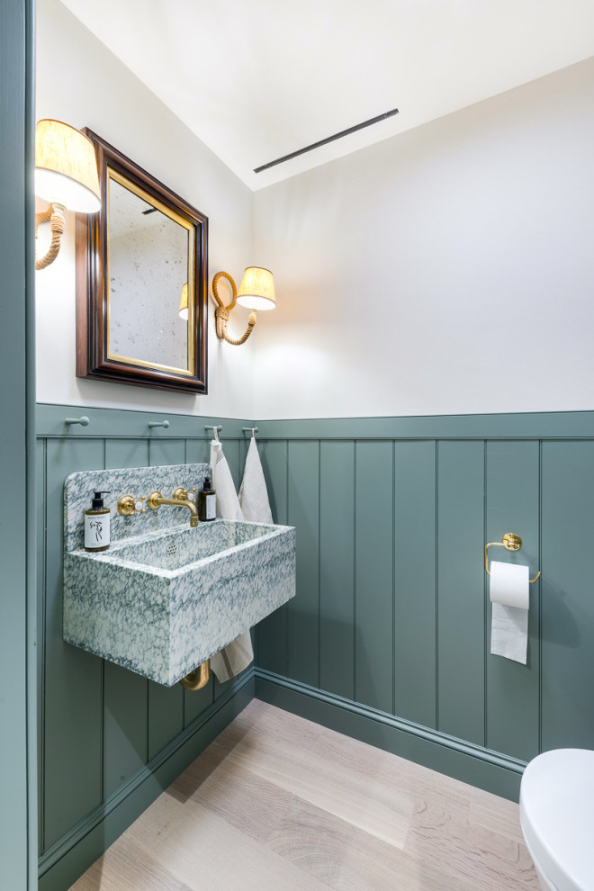 Kleine Klassische Gästetoilette mit hellem Holzboden, schwebendem Waschtisch und vertäfelten Wänden in New York