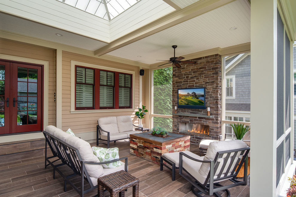 Inspiration for a large transitional backyard screened-in verandah in DC Metro with natural stone pavers and a roof extension.