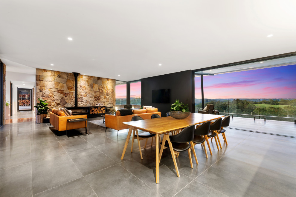 Contemporary open plan dining in Brisbane with black walls and grey floor.