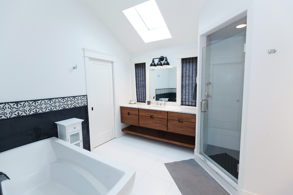 This is an example of a mid-sized transitional master bathroom in Chicago with flat-panel cabinets, medium wood cabinets, a freestanding tub, a corner shower, a two-piece toilet, black and white tile, mosaic tile, grey walls, porcelain floors, an undermount sink, marble benchtops, white floor and a hinged shower door.