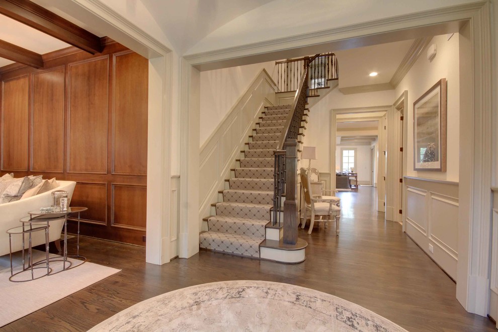 This is an example of a large transitional hallway in Atlanta with beige walls and dark hardwood floors.