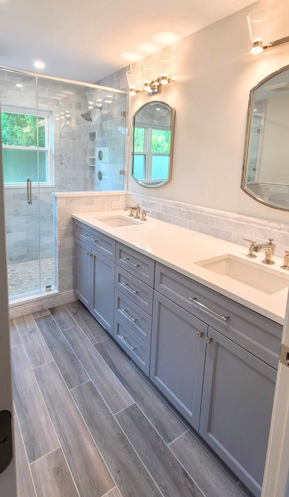 Inspiration for a large transitional master bathroom in Chicago with recessed-panel cabinets, grey cabinets, a double shower, gray tile, marble, grey walls, porcelain floors, an undermount sink, engineered quartz benchtops, brown floor, a hinged shower door, white benchtops, a niche, a double vanity and a built-in vanity.