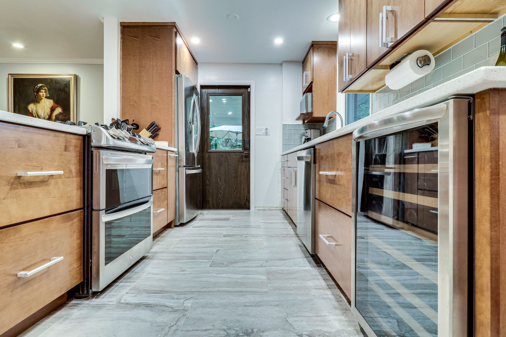 Foto på ett mellanstort 60 tals parallellkök, med en undermonterad diskho, bänkskiva i kvarts, rostfria vitvaror och en halv köksö