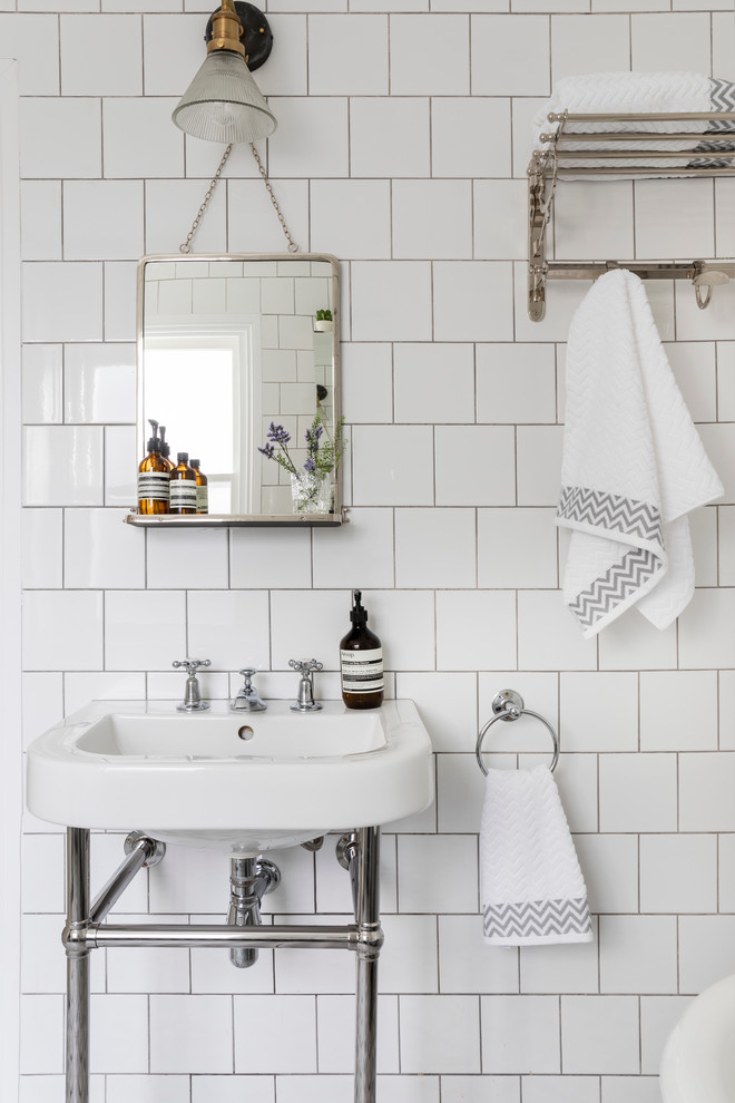 This is an example of a mid-sized traditional bathroom in London with white walls and a wall-mount sink.