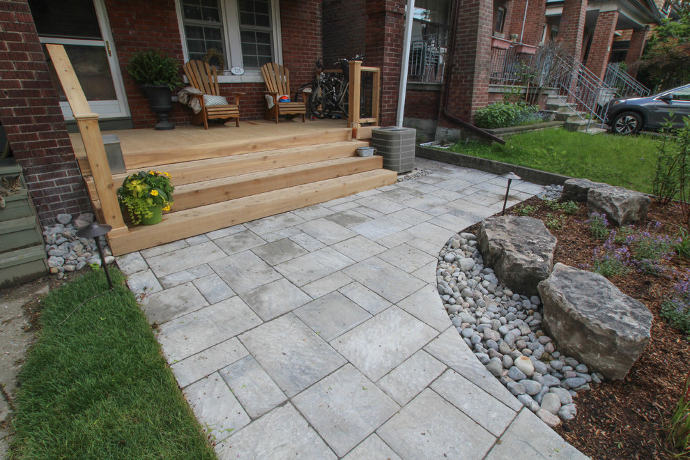 Photo of a small contemporary front yard verandah in Toronto with concrete pavers.