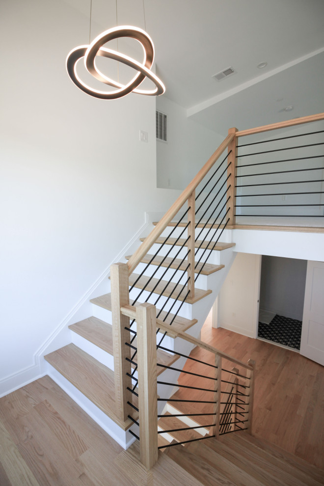 This is an example of a mid-sized contemporary wood floating staircase in DC Metro with painted wood risers, mixed railing and planked wall panelling.