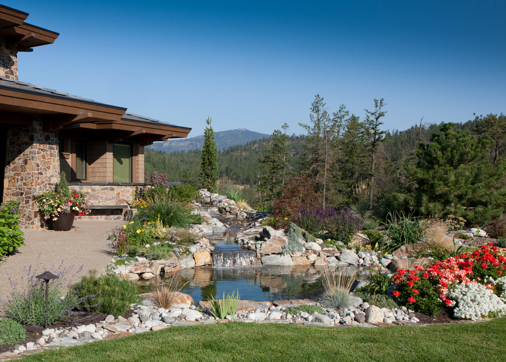 Photo of a mid-sized rustic front yard concrete paver pond for spring.