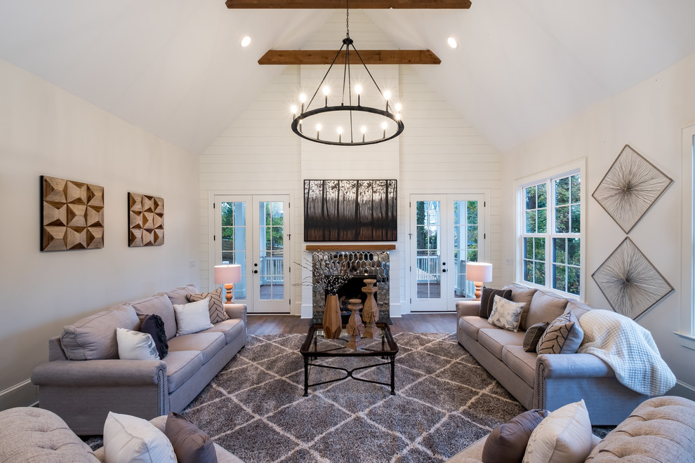 Country enclosed living room in Charlotte with white walls, medium hardwood floors, a standard fireplace, a metal fireplace surround and brown floor.