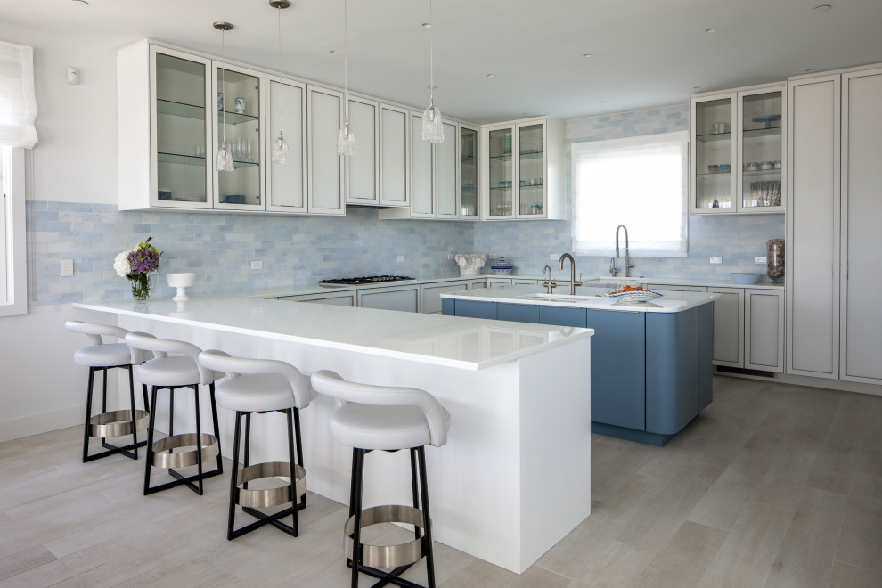 Photo of a mid-sized modern u-shaped separate kitchen in New York with an undermount sink, shaker cabinets, white cabinets, quartz benchtops, blue splashback, subway tile splashback, medium hardwood floors, with island, brown floor and white benchtop.