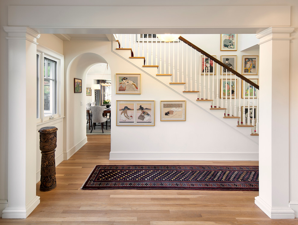 Design ideas for a mid-sized traditional hallway in Santa Barbara with white walls and light hardwood floors.